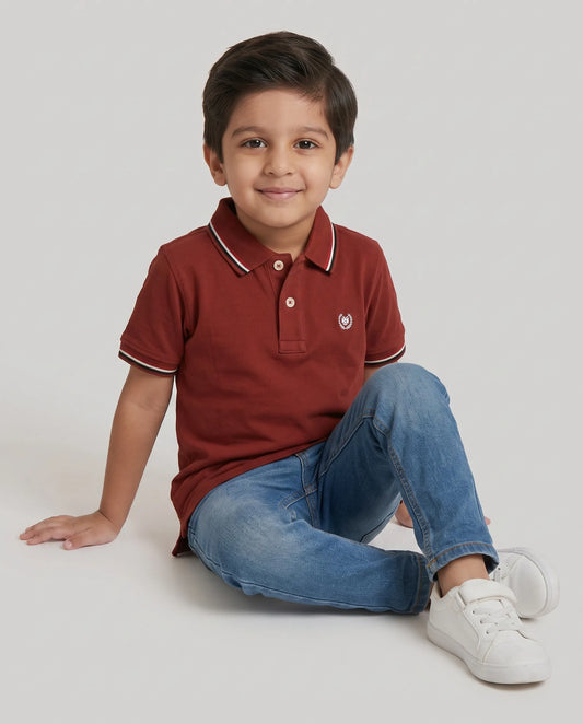 Boys rust red polo t-shirt close-up of embroidered Kidley crest badge
